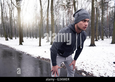 Young man exercising in snowy forest Banque D'Images