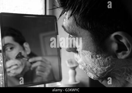 Rasage homme en miroir, à l'aide d'un pinceau, de la crème et rasoir Banque D'Images