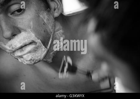 Rasage homme en miroir, à l'aide d'un pinceau, de la crème et rasoir Banque D'Images