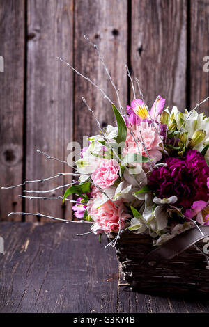 Bouquet rose et blanc de gillyflowers alstroemeria dans le panier sur l'ancien en bois rustique, historique Banque D'Images