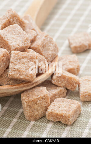 Brown Sugar cubes sur une cuillère en bois Banque D'Images