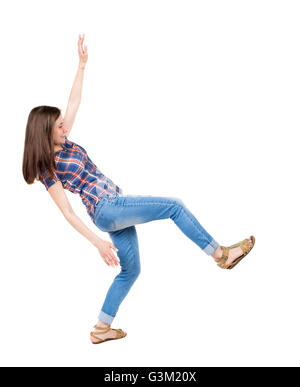 Jeune femme. L'équilibrage ou dodge tomber femme. Vue arrière Vue arrière. collection les gens de personne. Plus isolé sur fond blanc. Une jeune fille dans une tunique bleue avec bandes rouges smiling vacillé sur la jambe gauche. Banque D'Images