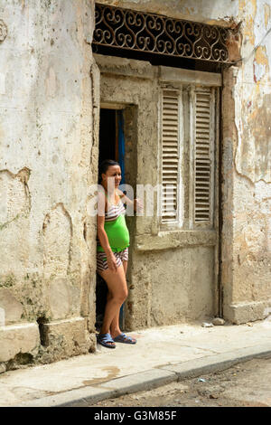 Une femme se tient dans l'embrasure d'une chambre dans la Vieille Havane, Cuba Banque D'Images