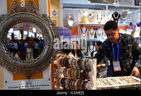 Kunming, province chinoise du Yunnan. 13 Juin, 2016. Un membre du personnel d'une entreprise indienne sortes de leurs bijoux et artisanat à la 4e China-South Asia Expo à Kunming, capitale du sud-ouest de la province chinoise du Yunnan, le 13 juin 2016. L'expo, qui dure du 12 juin au 17 juin, a attiré près de 5 000 exposants de 89 pays et régions. Credit : Lin Yiguang/Xinhua/Alamy Live News Banque D'Images