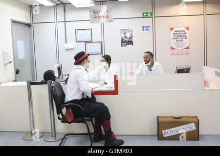 (160614) -- SAO PAULO, le 14 juin 2016 (Xinhua) -- Image prise le 9 juin 2016, montre Gilberto Kido (avant) recevoir du sang test avant un don de sang volontaire au 'pro' de la Fondation 1958 à Sao Paulo, Brésil. Gilberto Kido a été un don de sang volontaire au cours des 30 dernières années, après le décès de sa mère en attendant une greffe de rein. En utilisant son personnage de clown, Kido a pour objectif d'encourager le don de sang pour sauver des vies. La Journée mondiale du don de sang est célébrée chaque année le 14 juin. En 2016 le thème de la campagne est "sang nous relie tous", l'Organisation mondiale de la santé (W Banque D'Images