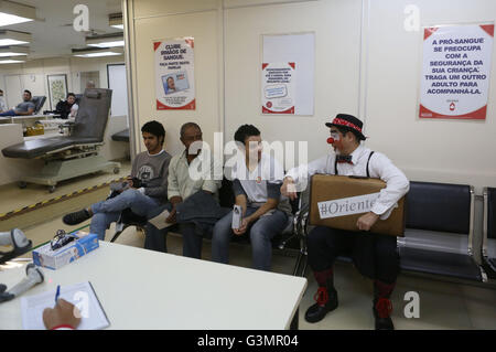 (160614) -- SAO PAULO, le 14 juin 2016 (Xinhua) -- Image prise le 9 juin 2016, montre Gilberto Kido (C), 50, parlant à d'autres donneurs de sang dans la salle d'attente à la 'pro' de la Fondation 1958 à Sao Paulo, Brésil. Gilberto Kido a été un don de sang volontaire au cours des 30 dernières années, après le décès de sa mère en attendant une greffe de rein. En utilisant son personnage de clown, Kido a pour objectif d'encourager le don de sang pour sauver des vies. La Journée mondiale du don de sang est célébrée chaque année le 14 juin. En 2016 le thème de la campagne est "sang nous relie tous", l'Organisation mondiale de la Santé (OMS) Banque D'Images