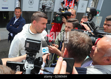 Evian, France. 14 Juin, 2016. L'Allemagne Lukas Podolski parle aux journalistes devant le centre des médias après une conférence de presse de l'équipe nationale de football allemande au terrain d'entraînement à côté d'équipe hotel à Evian, France, 14 juin 2016. L'UEFA EURO 2016 aura lieu du 10 juin au 10 juillet 2016 en France. Photo : Christian Charisius/dpa/Alamy Live News Banque D'Images