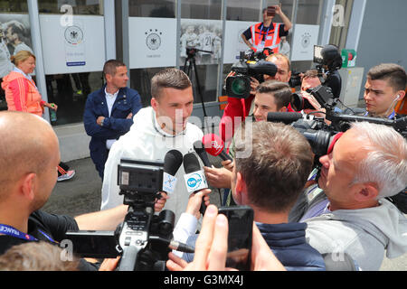 Evian, France. 14 Juin, 2016. L'Allemagne Lukas Podolski parle aux journalistes devant le centre des médias après une conférence de presse de l'équipe nationale de football allemande au terrain d'entraînement à côté d'équipe hotel à Evian, France, 14 juin 2016. L'UEFA EURO 2016 aura lieu du 10 juin au 10 juillet 2016 en France. Photo : Christian Charisius/dpa/Alamy Live News Banque D'Images