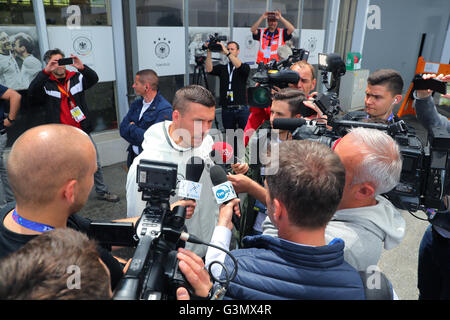 Evian, France. 14 Juin, 2016. L'Allemagne Lukas Podolski parle aux journalistes devant le centre des médias après une conférence de presse de l'équipe nationale de football allemande au terrain d'entraînement à côté d'équipe hotel à Evian, France, 14 juin 2016. L'UEFA EURO 2016 aura lieu du 10 juin au 10 juillet 2016 en France. Photo : Christian Charisius/dpa/Alamy Live News Banque D'Images