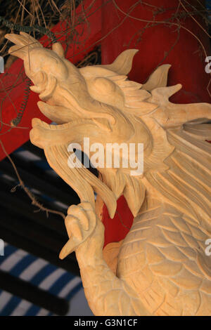 Bois sculpté dragon décorant un pilier dans un pavillon chinois à Hoi An (Vietnam). Banque D'Images