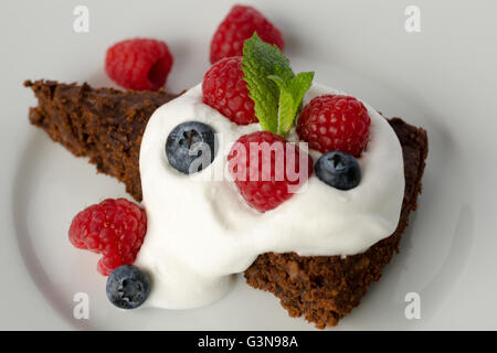 Gâteau au chocolat avec des framboises, myrtilles et crème Banque D'Images