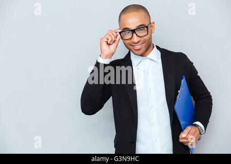 Portrait of smiling african businessman lunettes avec dossier bleu Banque D'Images