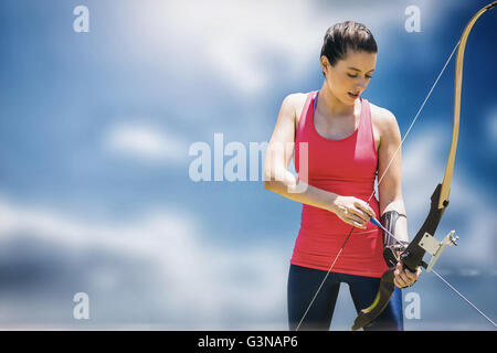 Image composite de l'athletic woman practicing archery Banque D'Images