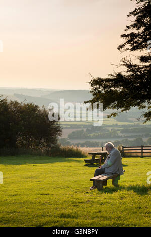 Vieux monsieur assis sur un banc de parc de pays, Buriton, Hampshire, Angleterre, Royaume-Uni, Europe Banque D'Images
