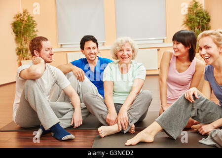 Senior woman et heureux groupe de personnes au centre de remise en forme au cours d'une pause Banque D'Images