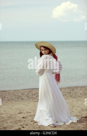 Femme à la plage portant robe vintage Banque D'Images