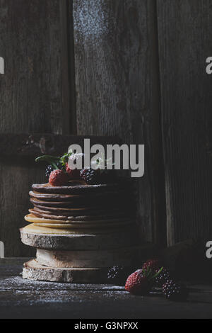 Des crêpes au chocolat avec des fruits biologiques sur des cales en bois avec fond de vieilles portes en bois Banque D'Images