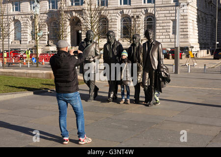 Liverpool, Merseyside, Pier Head Andrew Edwards' statue Beatles à l'extérieur du bâtiment du foie, les visiteurs qui prennent la photo souvenir Banque D'Images