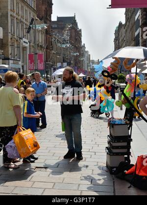 Un vendeur fabriquer et vendre des chiffres ballon par torsion long, de ballons, de Buchanan Street, Glasgow, Scotland, UK Banque D'Images