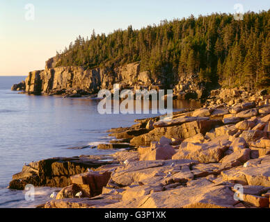 USA, le Maine, l'Acadia National Park, le lever du soleil la lumière sur les falaises et rochers de la loutre, le granit de la côte. Banque D'Images