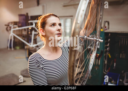 Portrait de femme la fixation d'un vélo dans un atelier vélo Banque D'Images