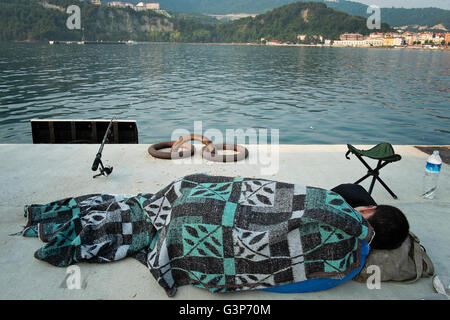 Un jeune homme se repose et attend qu'un poisson à accrocher sur sa ligne de pêche à la marina à Amasra, Turquie Banque D'Images