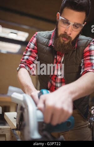 Carpenter en utilisant une scie sauteuse en atelier Banque D'Images