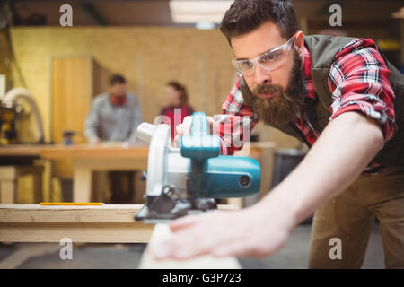 Carpenter en utilisant une scie sauteuse en atelier Banque D'Images