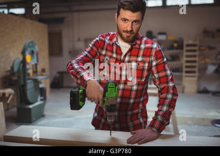 Carpenter using drill machine Banque D'Images