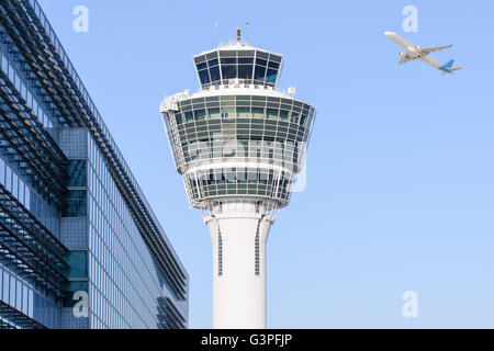 La tour de contrôle de l'aéroport international de Munich et la borne des immeubles modernes avec au départ de l'avion au décollage Banque D'Images