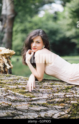 Belle jeune femme portant sur l'arbre Banque D'Images