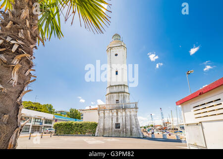 Vue sur le phare du 18ème siècle qui veille sur le port du canal, avec des bâtiments anciens et modernes dans la région de Rimini, Italie Banque D'Images