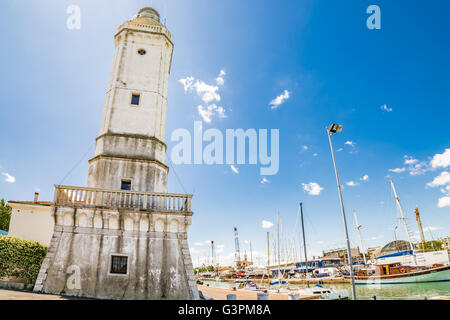 Vue sur le phare du 18ème siècle qui veille sur le port du canal, avec des bâtiments anciens et modernes dans la région de Rimini, Italie Banque D'Images