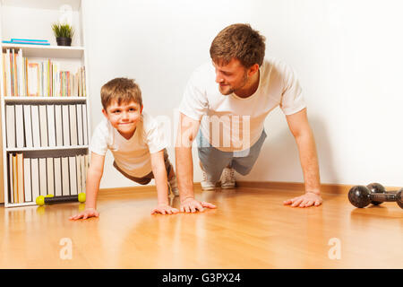 L'enseignement du père fils pour enfants faisant des exercices de push-ups Banque D'Images