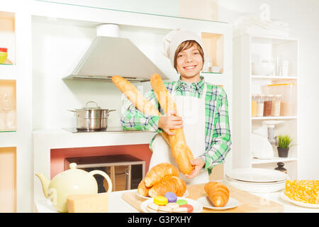 Young Baker avec les aliments de boulangerie frais à la cuisine Banque D'Images