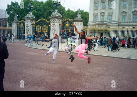 Un groupe de femmes noires américaines l'avoir pris en photo de sauter dans l'air à l'extérieur du palais de Buckingham. Banque D'Images