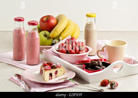 Le petit-déjeuner. Gâteau aux fraises et du café, des fruits et des baies fraise et banane smoothies. Focus sélectif. Banque D'Images