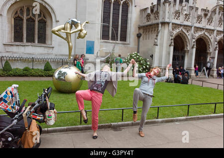 Deux femmes touristes virevoltantes devant la statue de la gymnaste à l'extérieur de l'abbaye de Westminster pendant les Jeux Olympiques de Londres. Banque D'Images