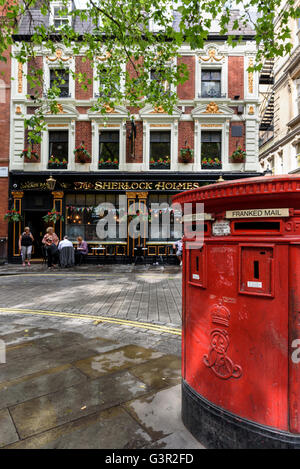 Post box rouge par les trous de Sherlock pub, Westminster, London, UK. Banque D'Images