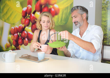 Man pouring boisson chaude pour companion Banque D'Images