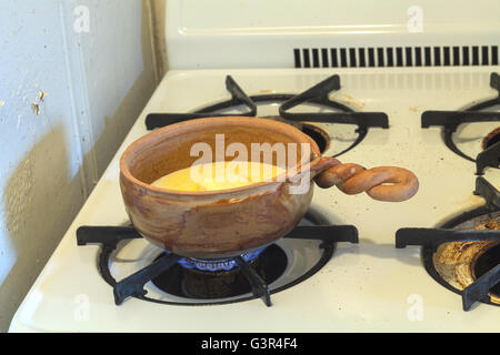 La série de fabrication du pain. Quatre cuillères à soupe de beurre avec une tasse de lait et trois quarts d'une tasse de sucre dans une casserole, chauffer à th Banque D'Images