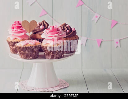 Cupcakes avec sweet rose des fleurs et une cakepick pour le texte Banque D'Images