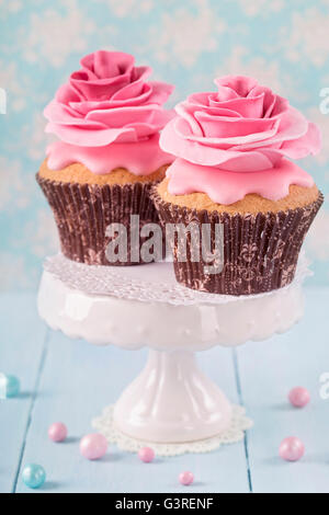 Cupcakes avec deux fleurs rose Banque D'Images