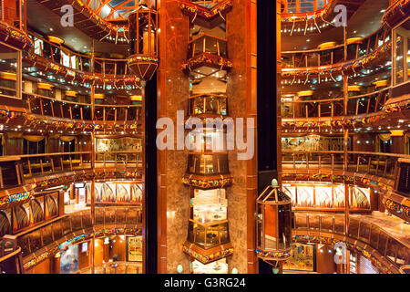 Le point de vue de l'intérieur coloré d'un paquebot de croisière avec des ascenseurs de verre dans un milieu. Banque D'Images