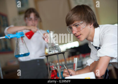 L'école secondaire lab partenaires prenant part à une expérience de chimie en classe de sciences. L'Angleterre. UK Banque D'Images