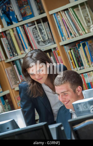 Élèves du secondaire à la recherche à l'écran d'un ordinateur dans la bibliothèque de l'école. L'Angleterre. UK Banque D'Images