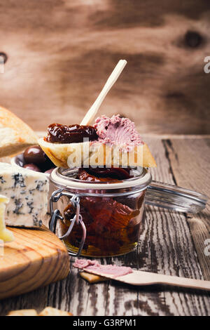 Bruschetta à la tomate confite et le pâté de foie de la viande. Antipasto parfait plat de démarreur sur plateau d'antipasti d'arrière-plan Banque D'Images