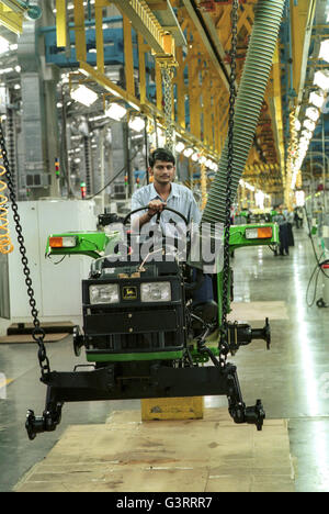 INDE, Pune, entreprise américaine John Deere Tractor Factory, employé travaillant à la chaîne de montage , production du tracteur John Deere 5103 pour le marché indien et pour l'exportation vers l'afrique, l'asie Banque D'Images