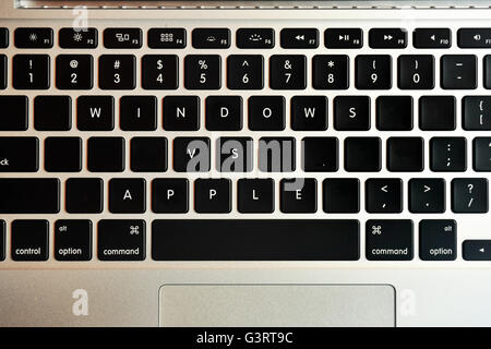 Windows vs Apple écrit sur le clavier d'un MacBook Pro. Banque D'Images