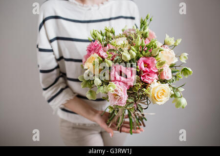 Riche bouquet de fleurs roses et rose eustoma, vert feuille dans la main bouquet frais du printemps. Arrière-plan de l'été. Banque D'Images